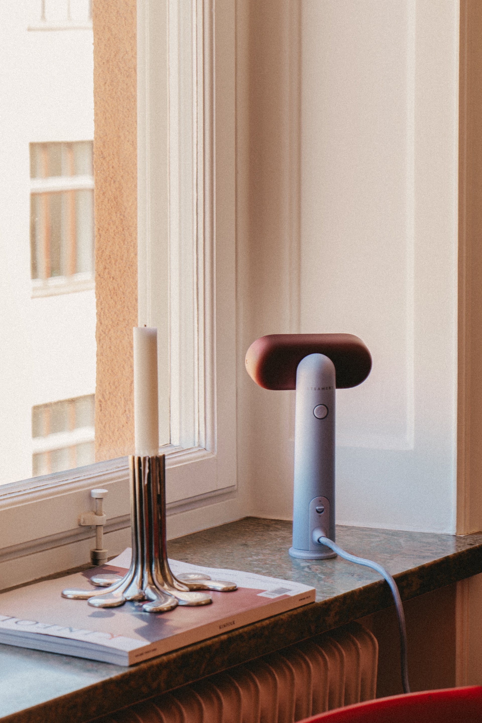 Candlestick and a travel steamer standing on a window seel