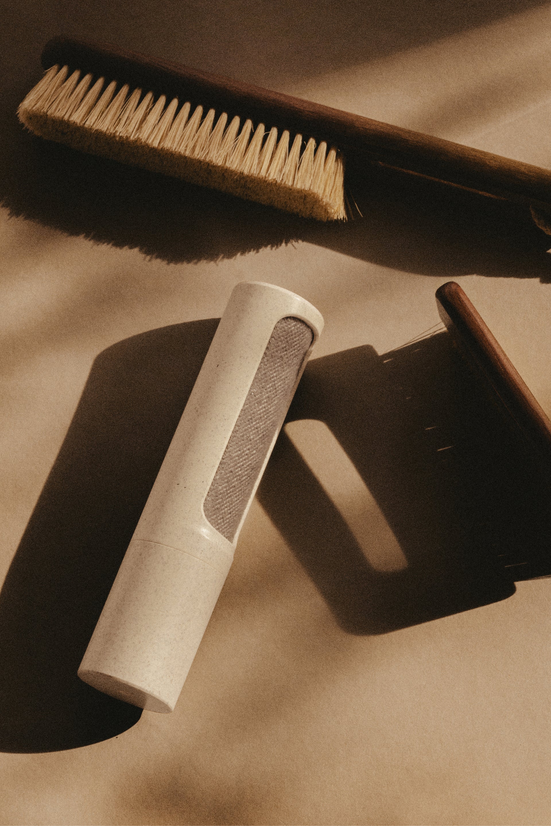 Set of 3 clothing brushes on a textured beige surface