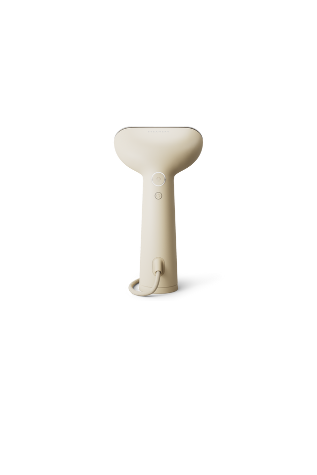 Beige handheld steamer on white background