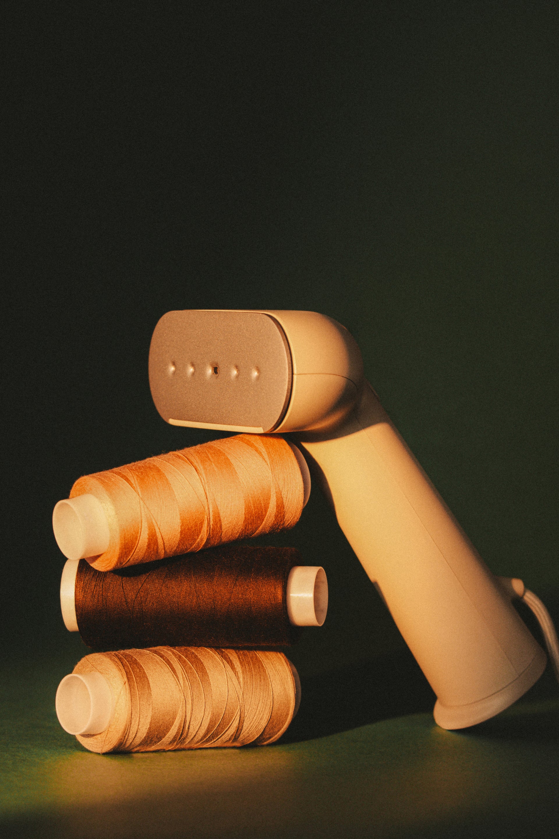 beige steamer leaning on 3 thread spools