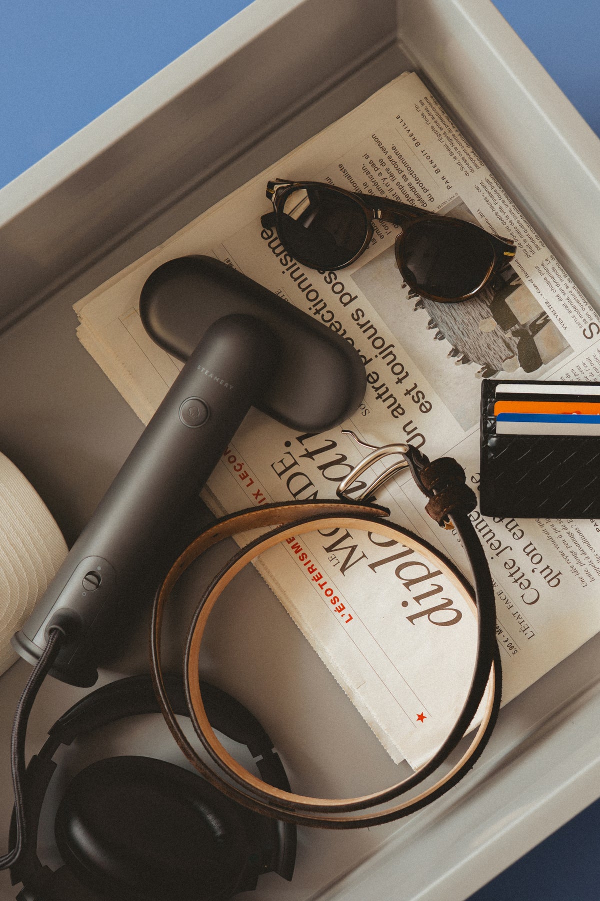 Black steamer in airport tray with travel items