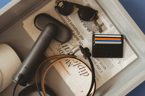Black steamer in airport tray with travel items
