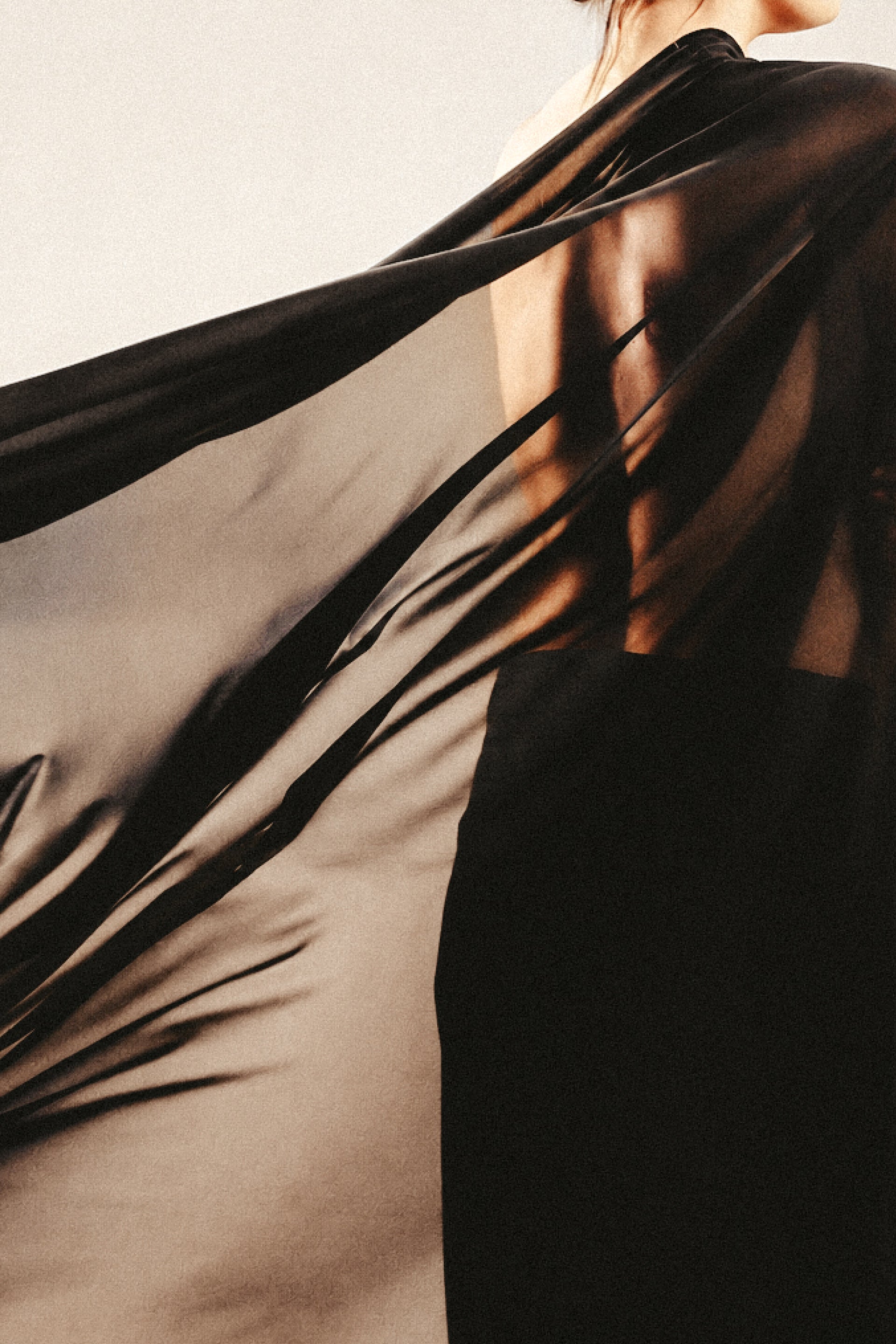 Black sheer fabric draped over a womans back