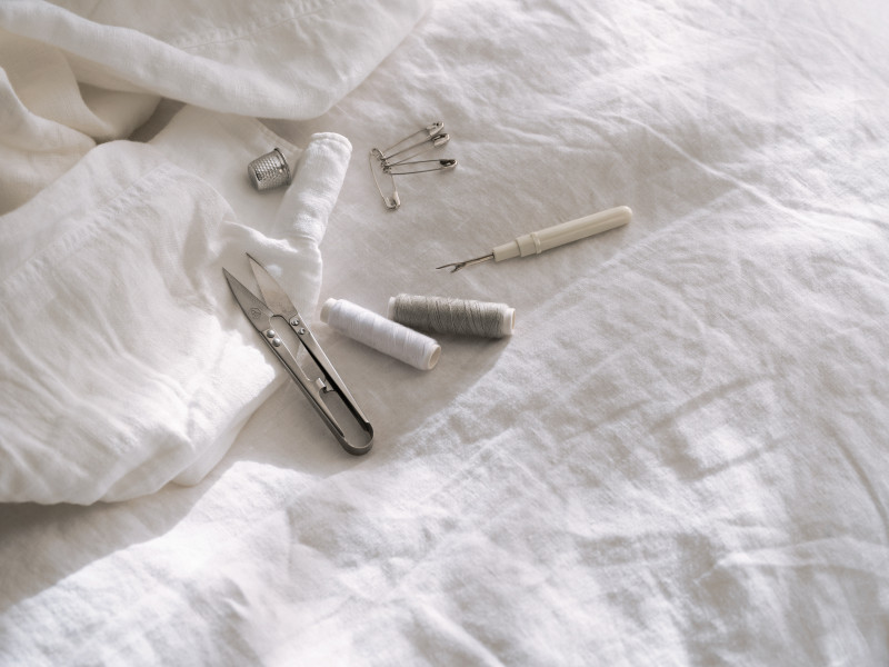 Sewing tools with a white linen background