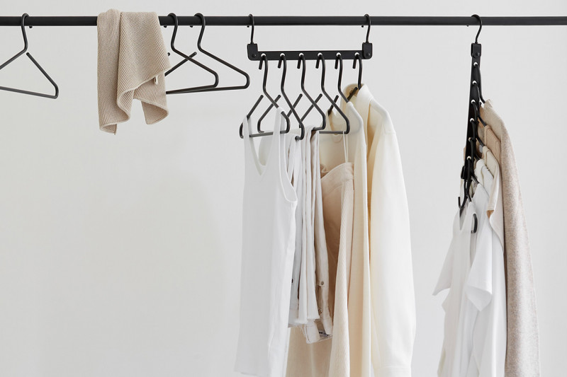 Garments in neutral colors hanging from a Space Saving Hanger