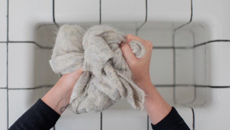 A person hand washing a wool sweater