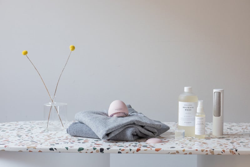 A collection of garment care products on a marble surface