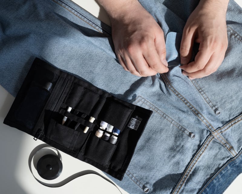 Someone mending a pair of jeans with a Sewing Kit